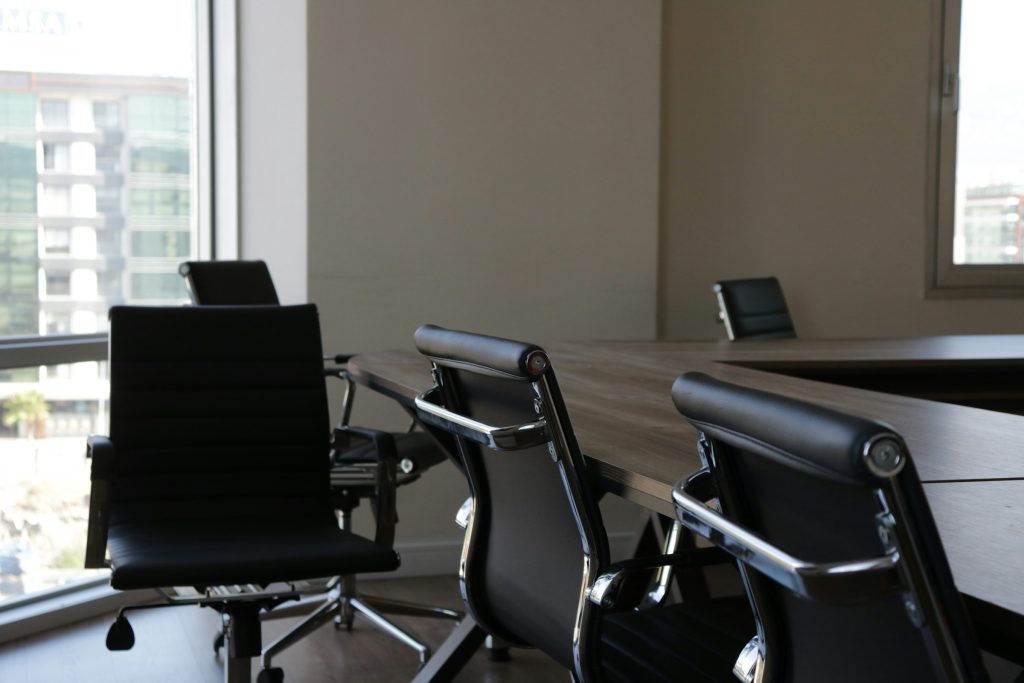 Sala riunioni con tavolo in legno e sedie nere